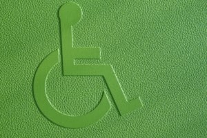 Disabled symbol on a green textured background. Horizontal